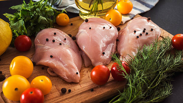 Raw chicken breast fillets and vegetable on wooden background Raw chicken breast fillets and vegetable on wooden background pink pepper spice ingredient stock pictures, royalty-free photos & images