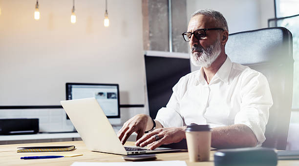 istock Middle age financial analyst wearing a classic glasses and working 623773284