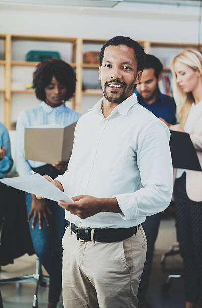 istock Teamwork concept in modern office.Young african businessman wearing white 623774554