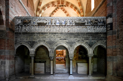  Albugnano, Italy - July 24, 2016: Arcades, pillars and romanesque sculptures of saints and human figures on the partition wall of the abbey of Santa Maria di Vezzolano, in Albugnano, on july 24, 2016. The abbey is an example of romanesque architecture in Piedmont