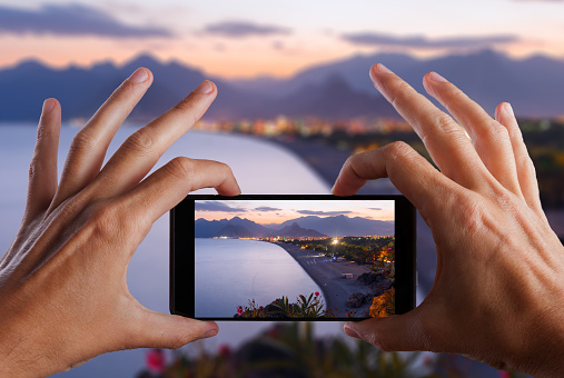 Travel concept. Hand making photo of city with smartphone camera