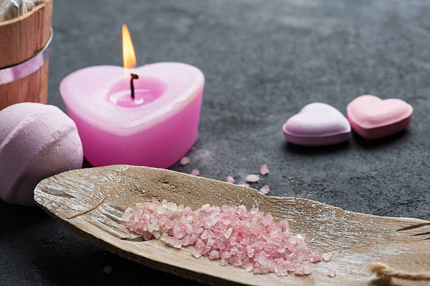 ванна бомба крупным планом с розовой зажженной свечой - candlelight concrete bathtub candle стоковые фото и изображения