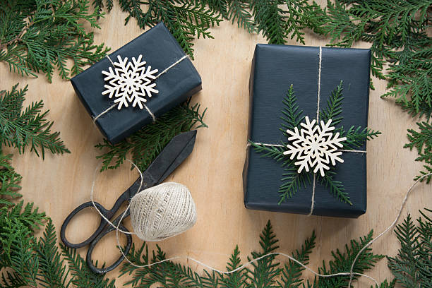 istock Christmas giftbox wrapped in black paper with decor on board. 623779264