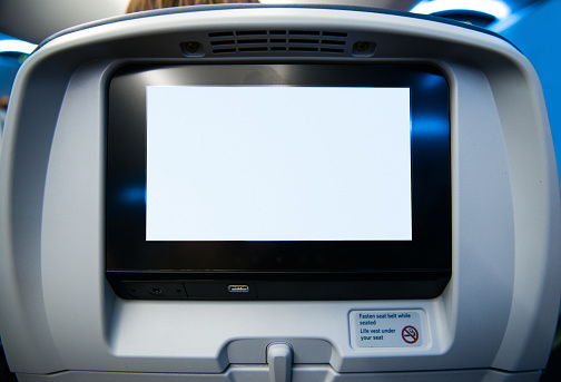 Passenger view of blank movie screen on the head rest directly in front of them.