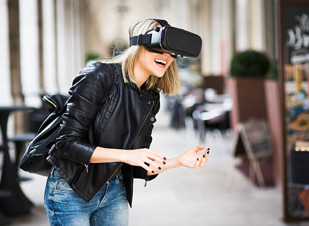 des femmes testent un simulateur de réalité virtuelle dans la rue - visiocasque photos et images de collection