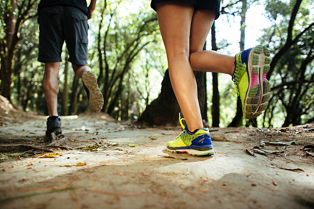 istock Low section of latin couple running in the forest 623823698