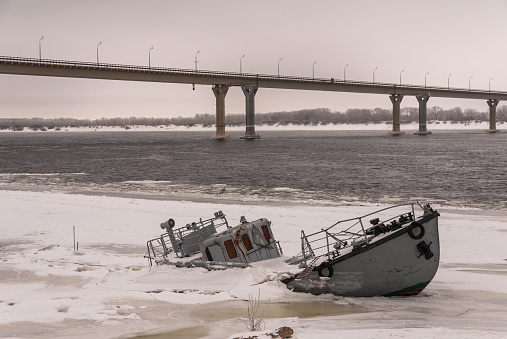 Vessel wreck in a frozen river covered with ice