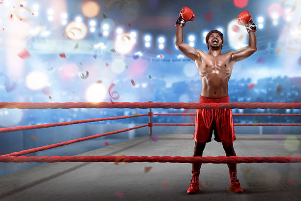 Cheerful asian young boxer is celebrating his winning in the boxing ring