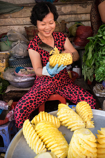 Close-up of hands peeling a pineapple using a pineapple corer.