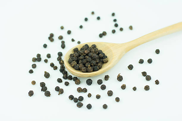istock Black pepper in spoon wooden bowl isolated on white background 623825064