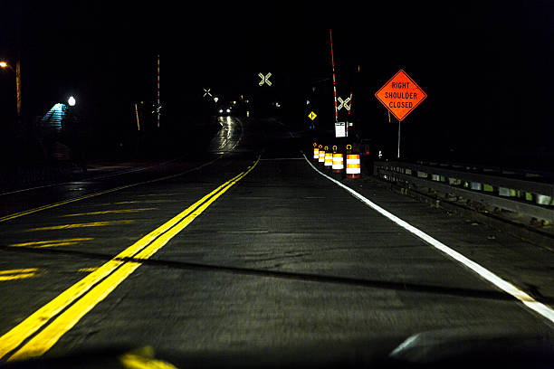 暗い踏切道路交差点に近づく夜車の運転手の視点 - crossing railroad track boundary gate ストックフォトと画像