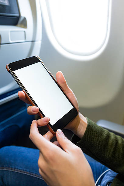 istock Woman holding a smart phone on airplane 623826668