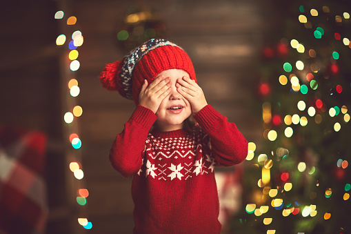 little girl closed eyes  her hands in anticipation of a Christmas miracle and a gift