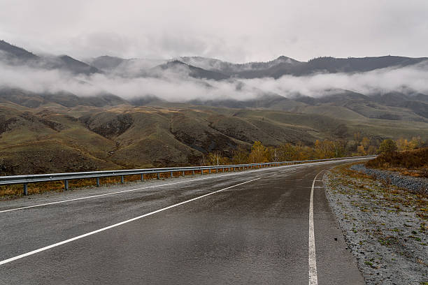 road mountains fog asphalt cloudy