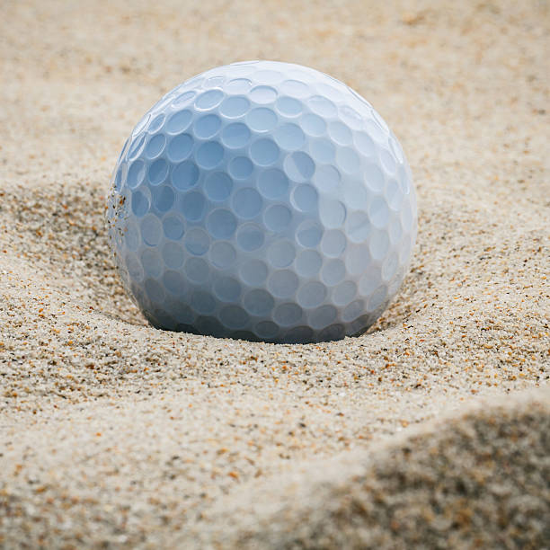 istock Close up golf ball in sand bunker shallow depth of 623858184