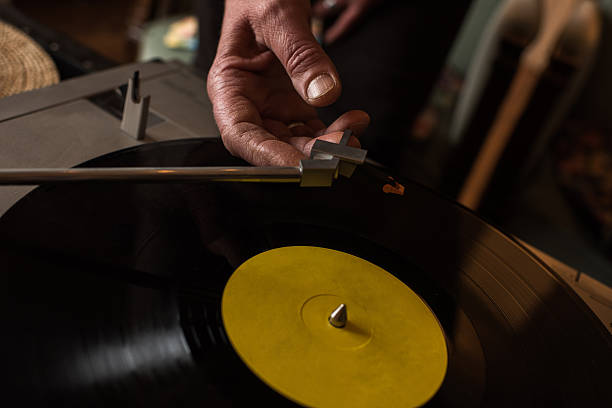 Close up of playing music on a turntable. Close up of unrecognizable person about to play the music on a gramophone. record player needle stock pictures, royalty-free photos & images