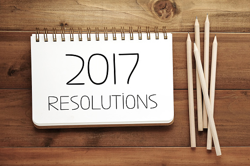 2017 resolutions on paper note book background, new year and business concept