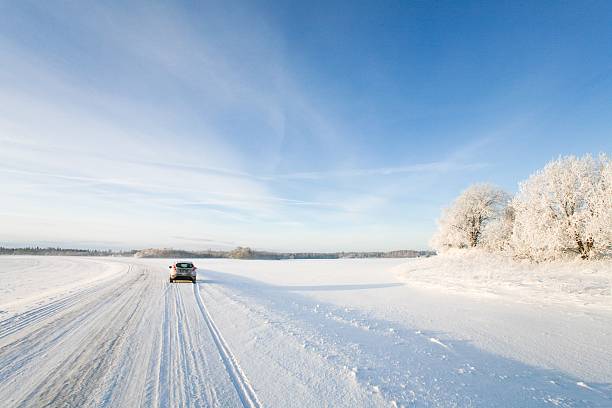 istock Small car driving along a snowy, icy road in winter 623865086