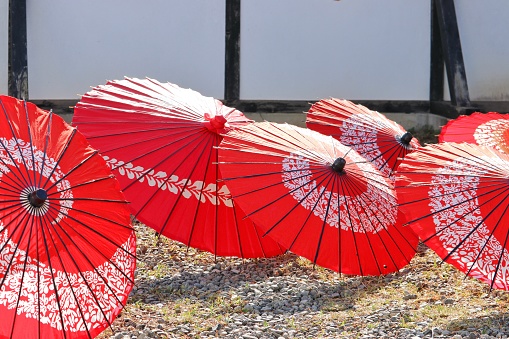 A red beach umbrella with blue sky and turquoise sea.