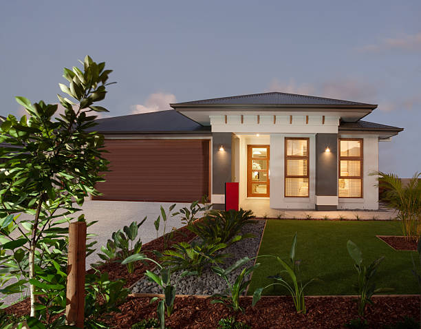 istock Modern house with green lawn garden illuminated at night 623867560