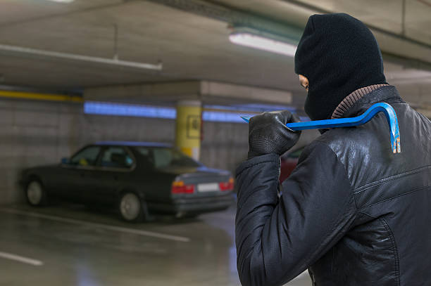 istock Thief with crowbar is going to steal car from garage. 623869710