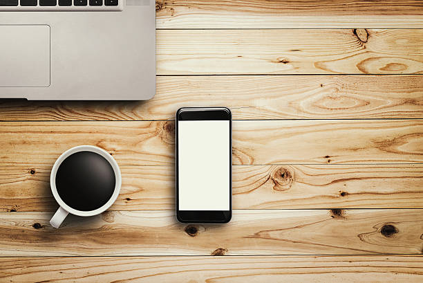 istock Smartphone laptop and coffee cup on wood 623879430