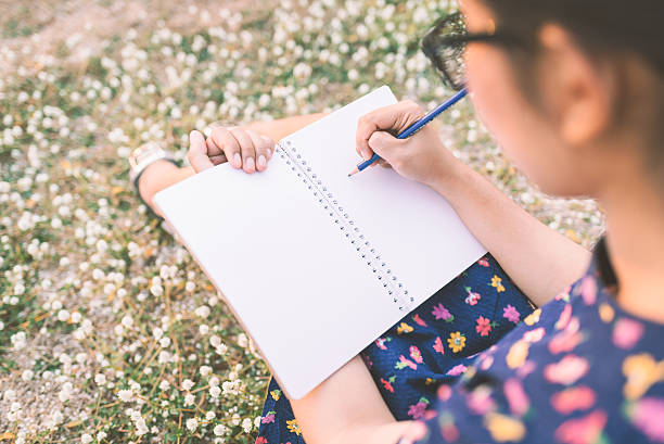 istock woman writing in her diary on the meadow 623880008
