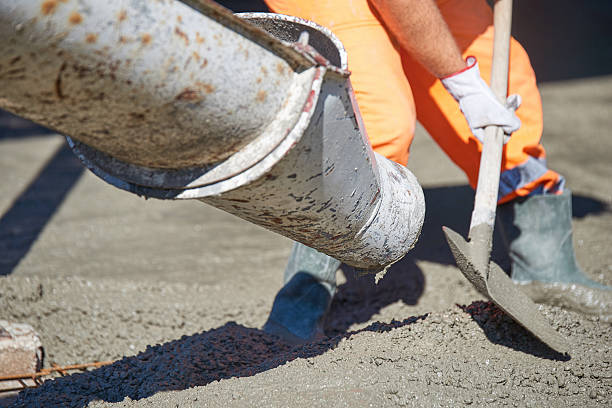 versamento di calcestruzzo durante i pavimenti di cementazione commerciale dell'edificio - level rod foto e immagini stock