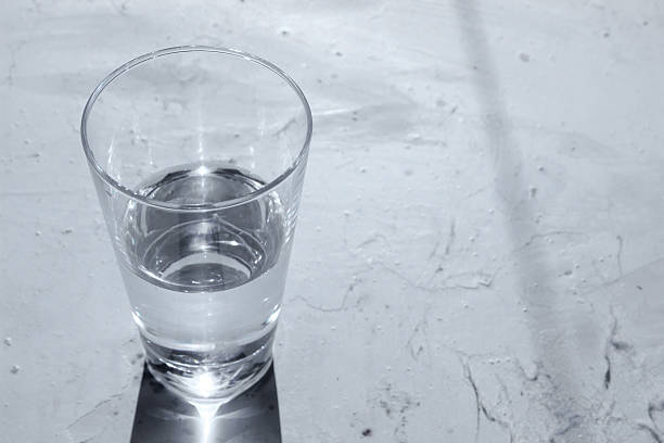 istock Glass of water with shadow on the white metallic table 623886204