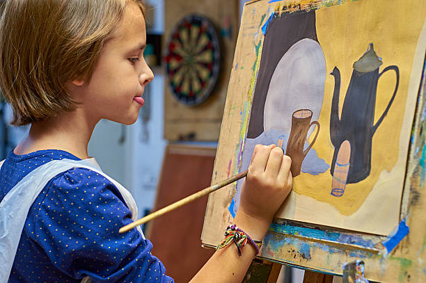 Schoolgirl painting a picture. stock photo