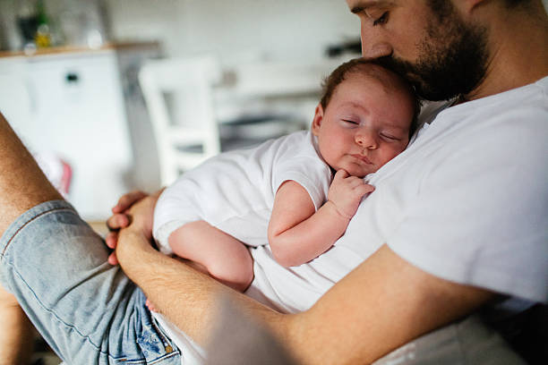 Napping time Father holding his baby boy who is falling asleep   napping photos stock pictures, royalty-free photos & images