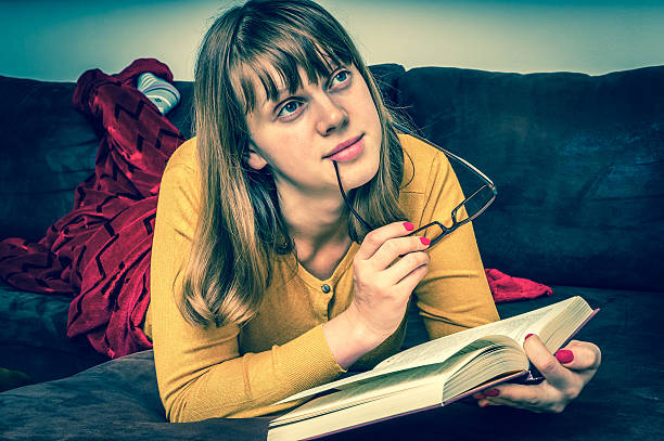istock Young beautiful girl reading a book 623889470