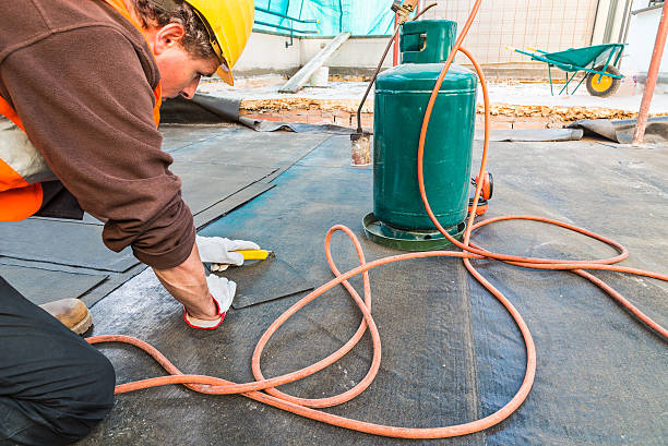 istock Roofer installing rolls of bituminous waterproofing membrane on a terrace 623889636