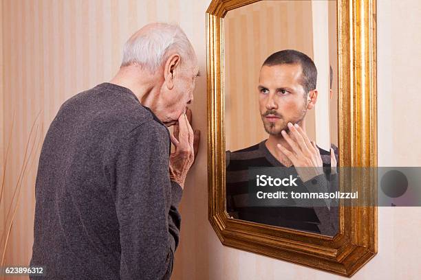 Foto de Homem Mais Velho Olhando Para Um Jovem No Espelho e mais fotos de stock de Espelho - Espelho, Individualidade, Terceira idade