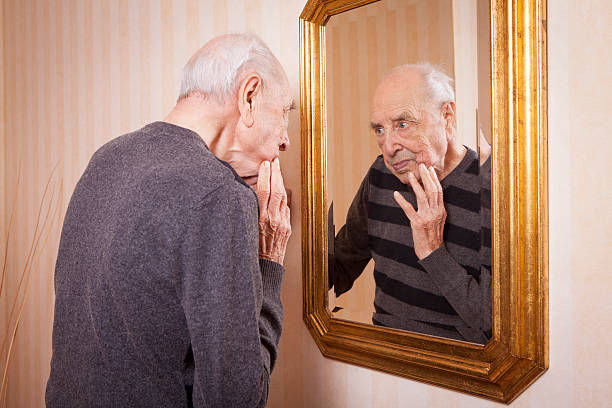 istock elder man looking at himself at the mirror 623896644