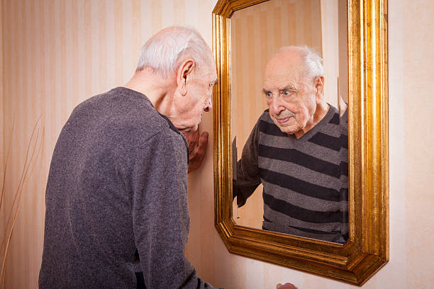 istock elder man looking at himself at the mirror 623896942