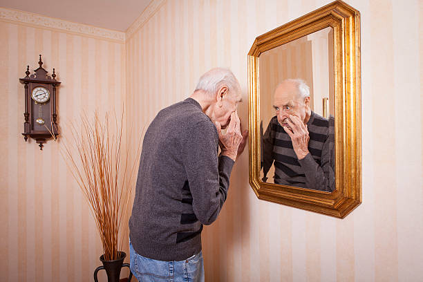 istock elder man looking at himself at the mirror 623897220