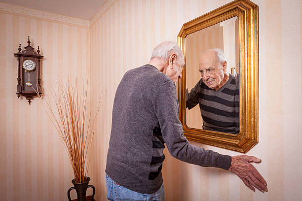 istock elder man looking at himself at the mirror 623897514