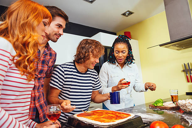 istock Man putting tomato sauce on pizza dough 623898178