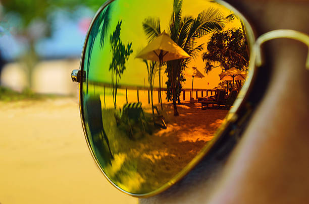 Reflection in the sunglasses on the girl on the ocean beach.