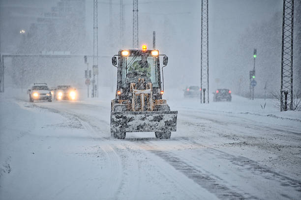 istock Snowplow tractor on snowstorm road 623900162