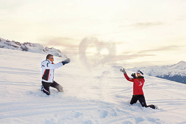 skifahrer paar liebe spielen schnee spritzen herz winter berge landschaft - pair cheerful happiness heterosexual couple stock-fotos und bilder