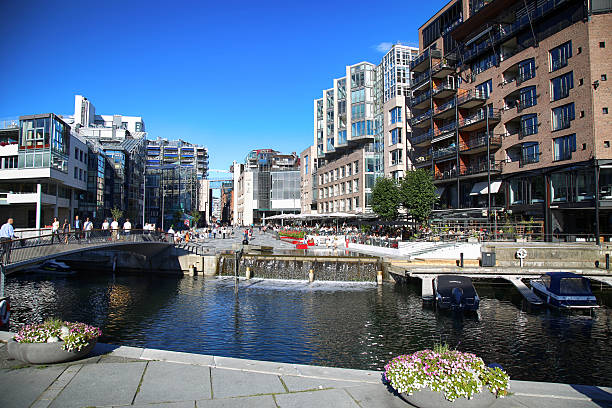 Oslo, Norway - August 17, 2016: OSLO, NORWAY â AUGUST 17, 2016: People walking on wonderful modern residential district Aker Brygge with lux apartments, shopping, culture and restaurants in Oslo, Norway on August 17,2016.