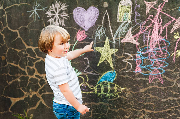 istock Cute toddler boy drawing with chalk 623908714