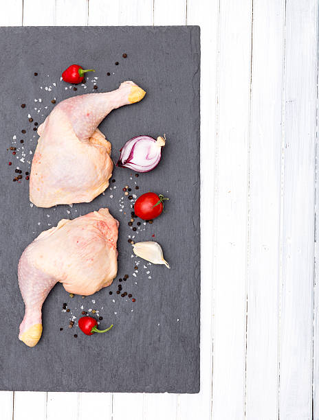 istock Raw chicken thighs with salt and spices on stone plate 623909996