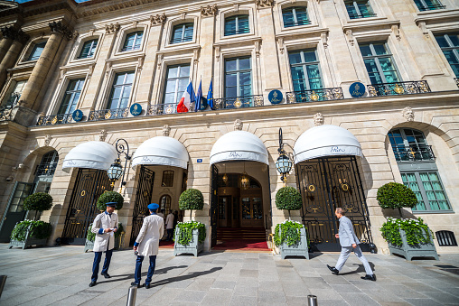Paris, France  - September 26, 2016: Famous Hotel Ritz on Place Vendome, Paris. Man walking to the hotel. Concierges at the entrance. 