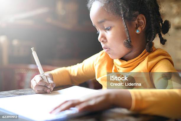 Foto de Uma Garotinha Africana Escrevendo e mais fotos de stock de Criança - Criança, Escrever, Matemática - Opção Educacional