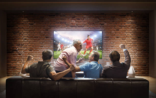 istock Adults watching Soccer game at home 623912248