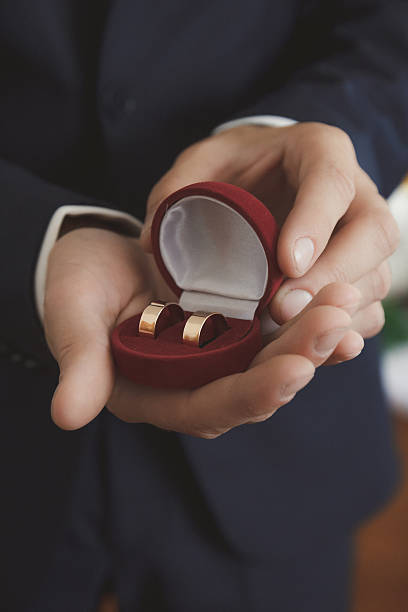 istock Golden wedding rings in groom's hands 623912264