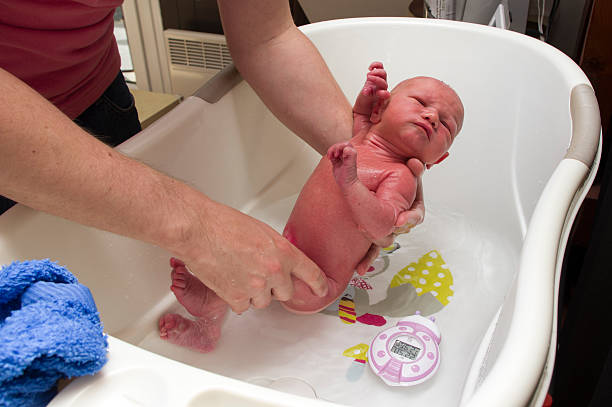 new born baby bathing Three days old  baby boy having his bath baby bath stock pictures, royalty-free photos & images